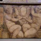 ...sorretto da due putti